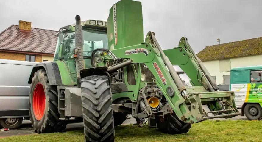 Zielony ciągnik Fendt 714 Vario z ładowaczem czołowym. Dane techniczne tego modelu są imponujące.