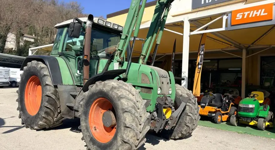 Zielony traktor Fendt 716 z ładowaczem, obok sklepu Raggi. Dane techniczne tego modelu są imponujące.