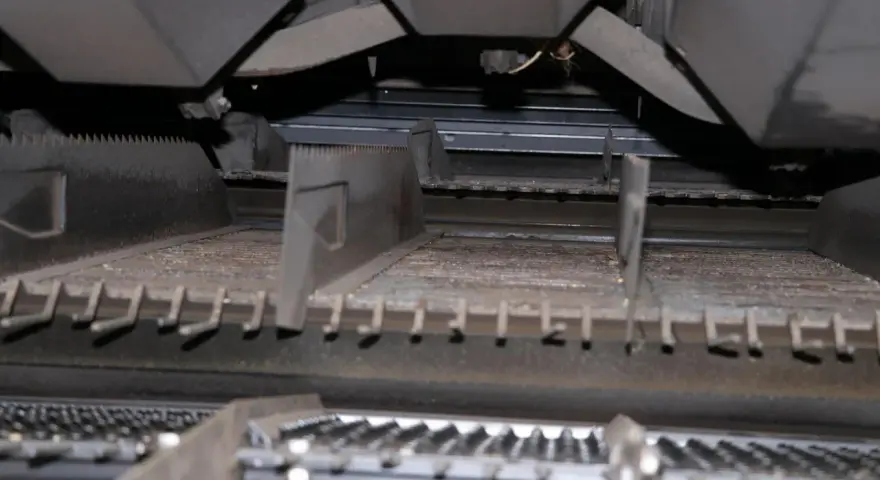 Wnętrze kombajnu z widocznym elementem roboczym, przypominającym ząbkowany rotor.