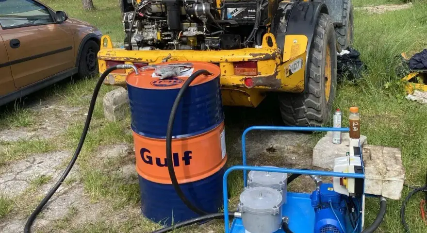 Ważne jest, jak sprawdzić poziom oleju hydraulicznego w koparce. Na zdjęciu widać beczkę Gulf i pompę do uzupełniania płynu.