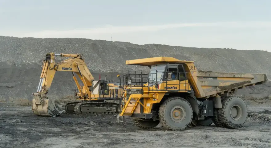 Żółty koparka i wywrotka Komatsu na placu budowy. Poznaj nazwy maszyn budowlanych, które pracują w trudnych warunkach.