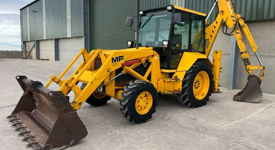 Żółta koparko ładowarka MF 50, gotowa do pracy. Dane techniczne tej maszyny to jej mocne strony.