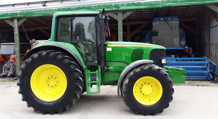 Zielony traktor John Deere 6820, z żółtymi felgami, gotowy do pracy. Dane techniczne tego modelu są imponujące.