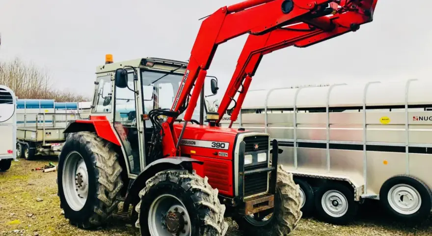 Czerwony ciągnik Massey Ferguson 390 z ładowaczem czołowym, gotowy do pracy. Dane techniczne tego modelu są imponujące.