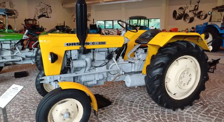Żółty Ursus C-330, idealny ciągnik na 30 ha, prezentowany w muzeum.
