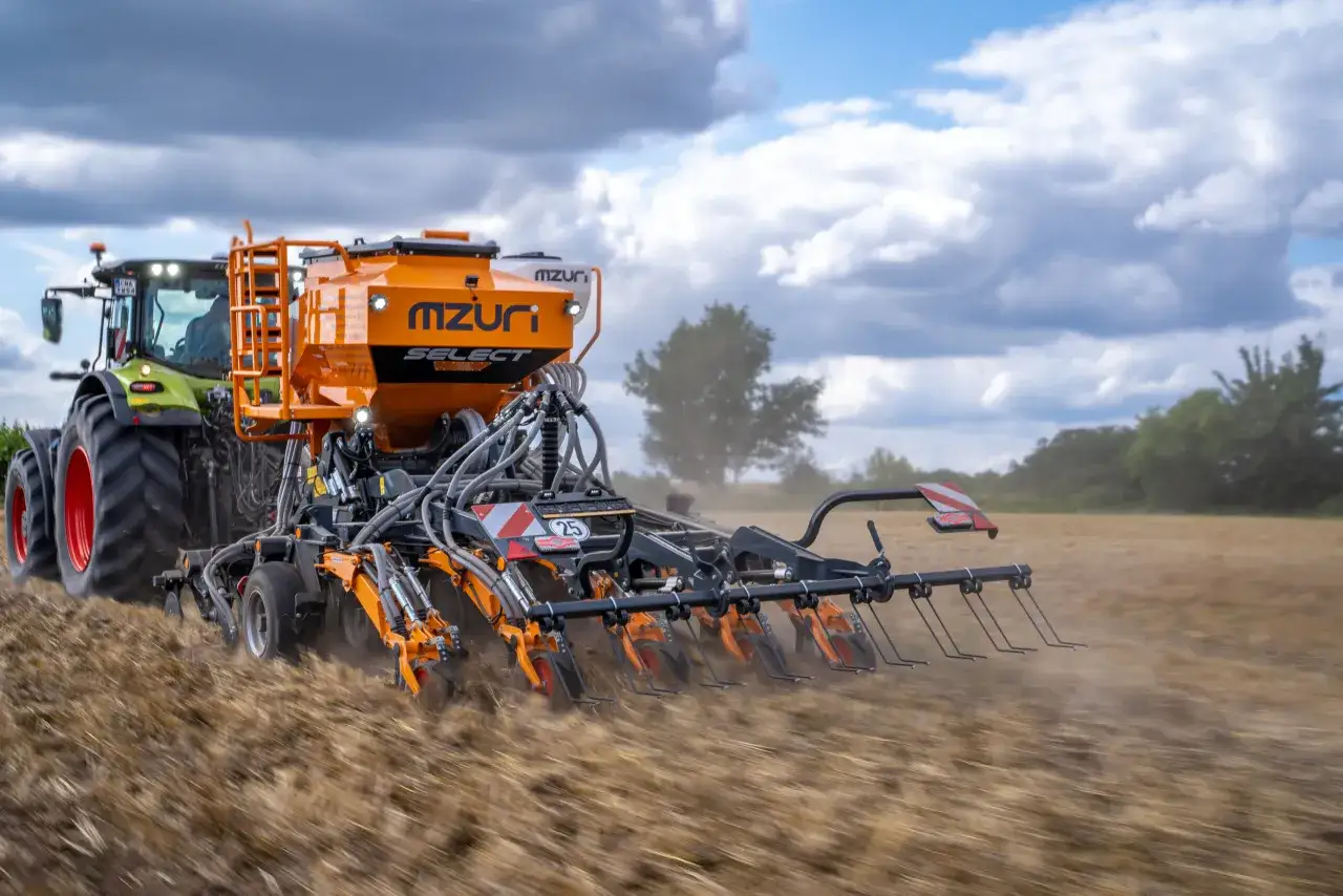Traktor z siewnikiem Mzuri Select pracuje na polu, wykonując uprawę bezorkową. To idealny agregat do siewu bezpośredniego.