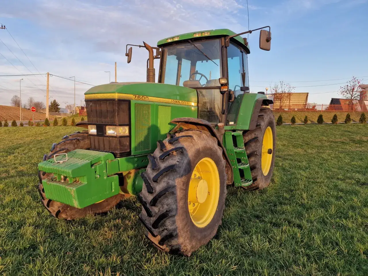 Zielony traktor John Deere 7600 na trawie. Poznaj john deere 7600 dane techniczne tego potężnego sprzętu rolniczego.