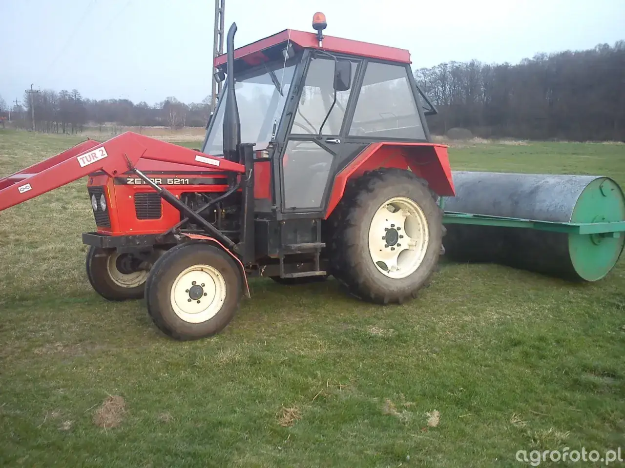 Czerwony Zetor 5211 z ładowaczem TUR 2 i walcem przygotowuje pole. Zastanawiasz się nad zetor 5011 spalanie?