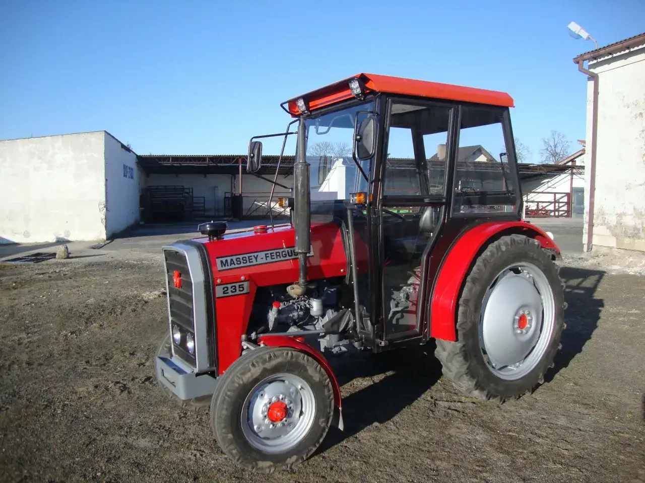 Czerwony ciągnik Massey Ferguson 235, gotowy do pracy. Poznaj jego massey ferguson 235 dane techniczne i możliwości.