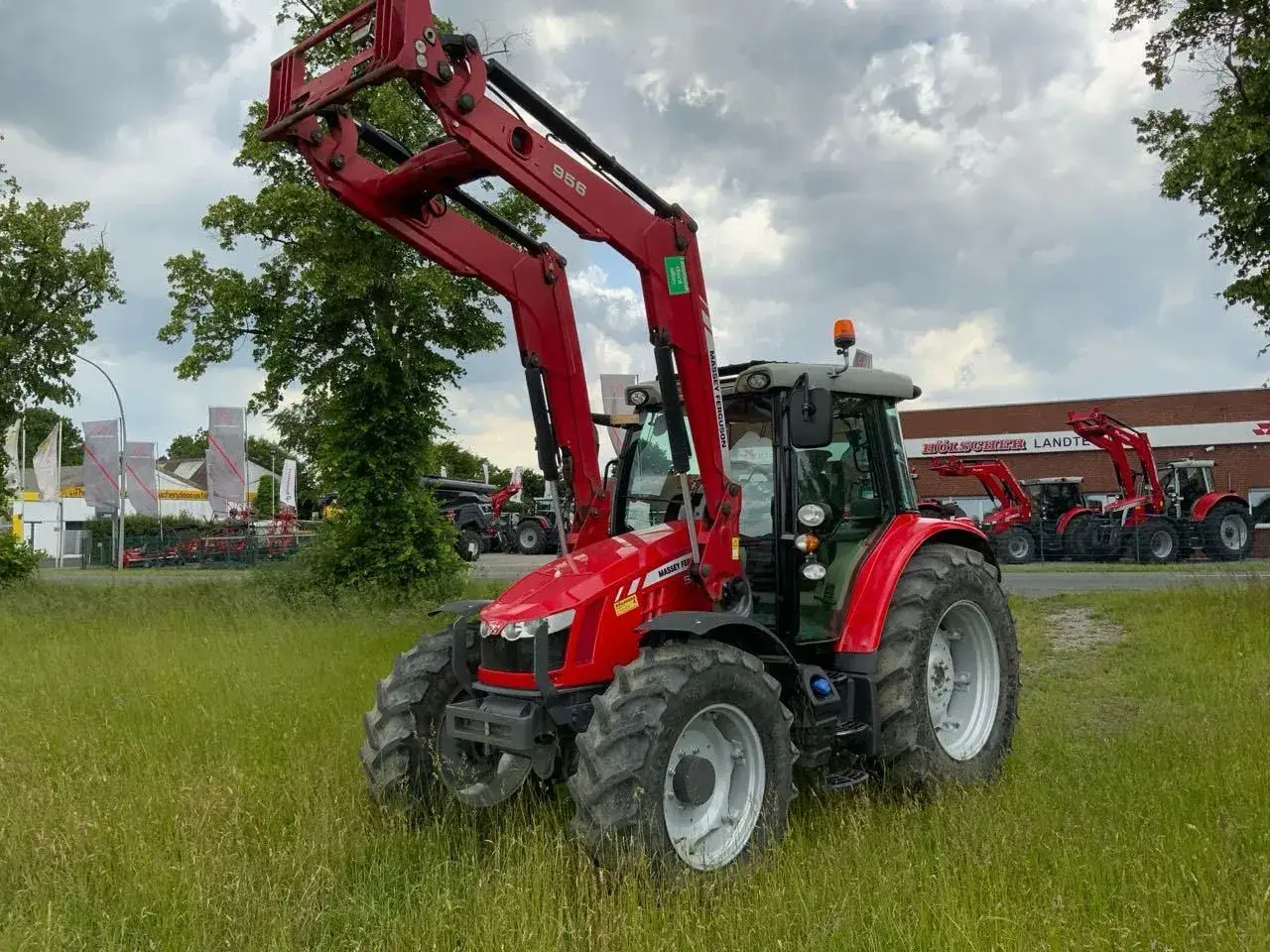 Czerwony traktor Massey Ferguson z ładowaczem czołowym. Dane techniczne MF 6290 są imponujące, gotowy do pracy na polu.