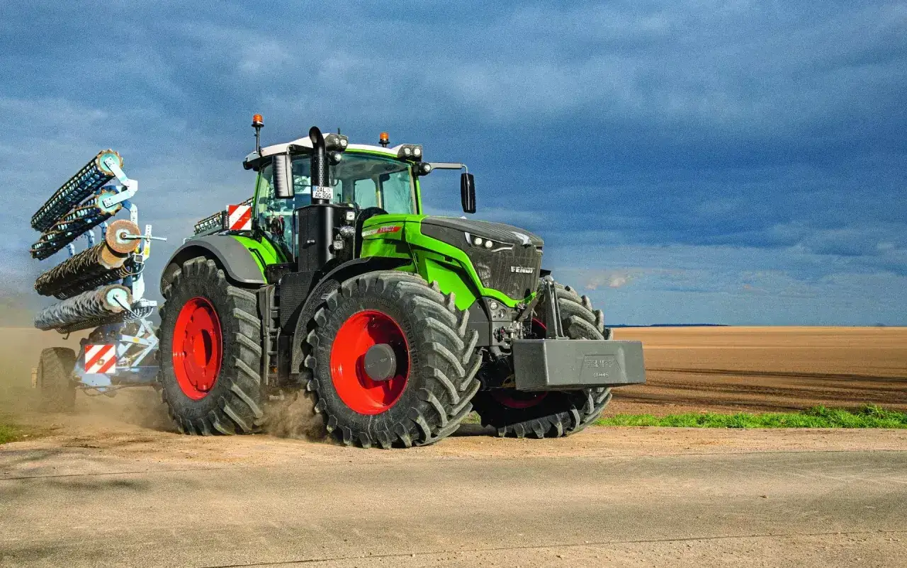 Potężny zielony traktor Fendt 1050 z przyczepionym agregatem uprawowym, pracujący na polu. Poznaj jego imponujące fendt 1050 dane techniczne.