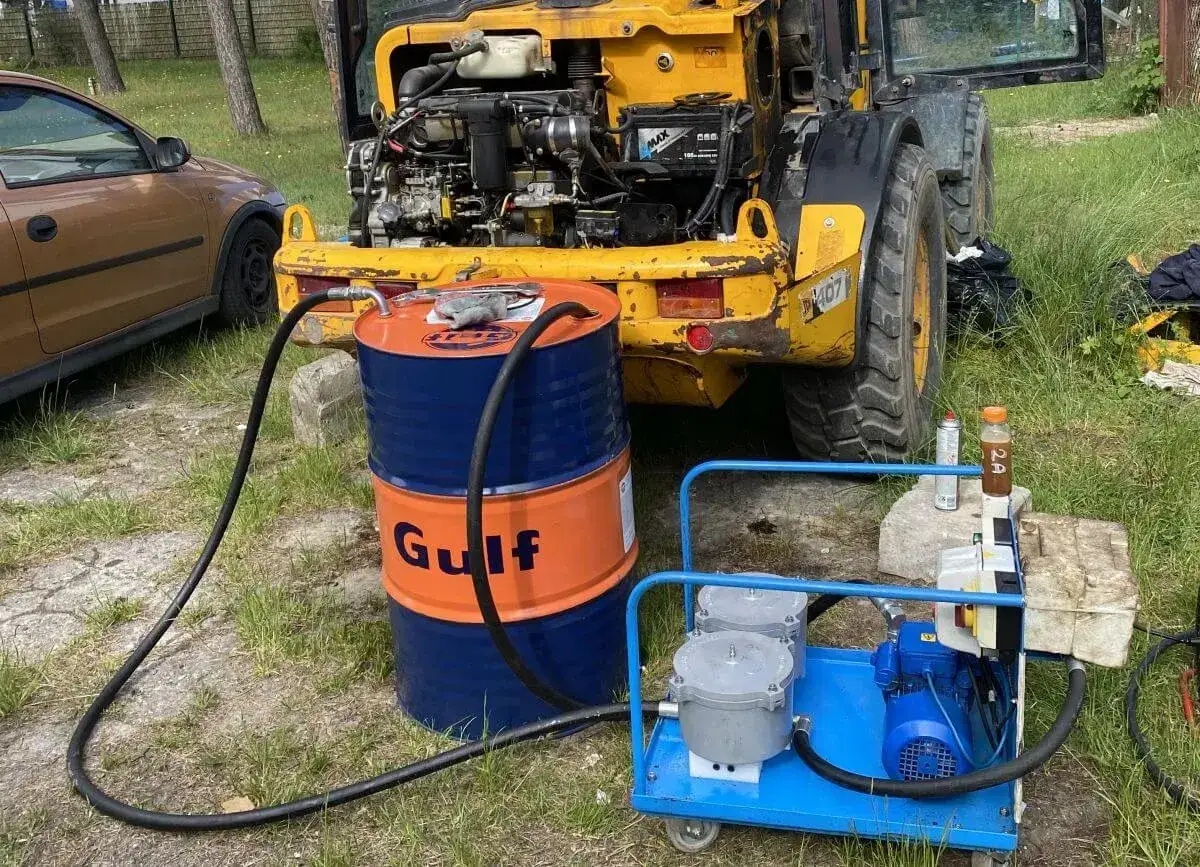 Pompa do oleju hydraulicznego zasysa płyn z beczki Gulf, by uzupełnić poziom w koparce.