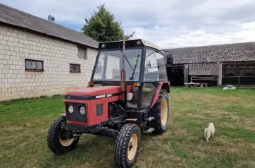 Czerwony Zetor 5011 na trawie, obok budynków gospodarczych. Zastanawiasz się nad jego spalaniem?